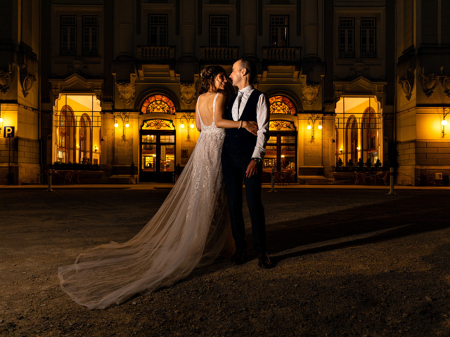 A newlywed couple dancing in front of a venue at night - Wedding photography. 